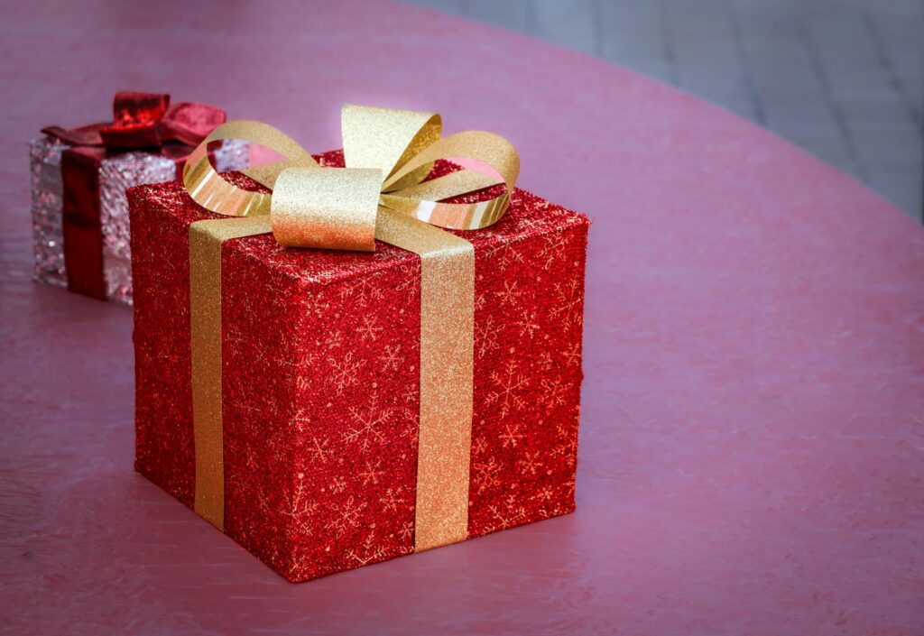 Elegant red gift box with gold ribbon, perfect for Christmas celebrations and holiday gifting.