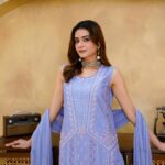 A woman in an elegant embroidered dress posing indoors in Lahore, Pakistan.