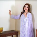 Portrait of a woman in Lahore wearing a beautiful embroidered lavender dress with traditional decor.