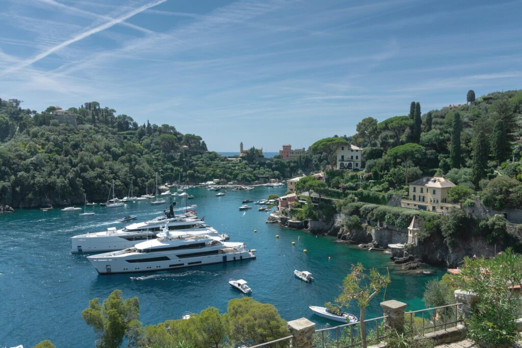 Stunning view of luxury yachts in the picturesque harbor of Portofino, Italy, on a sunny day.