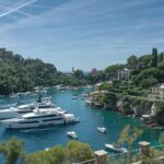 Stunning view of luxury yachts in the picturesque harbor of Portofino, Italy, on a sunny day.