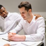 Coworkers showing emotional support in a modern office environment.